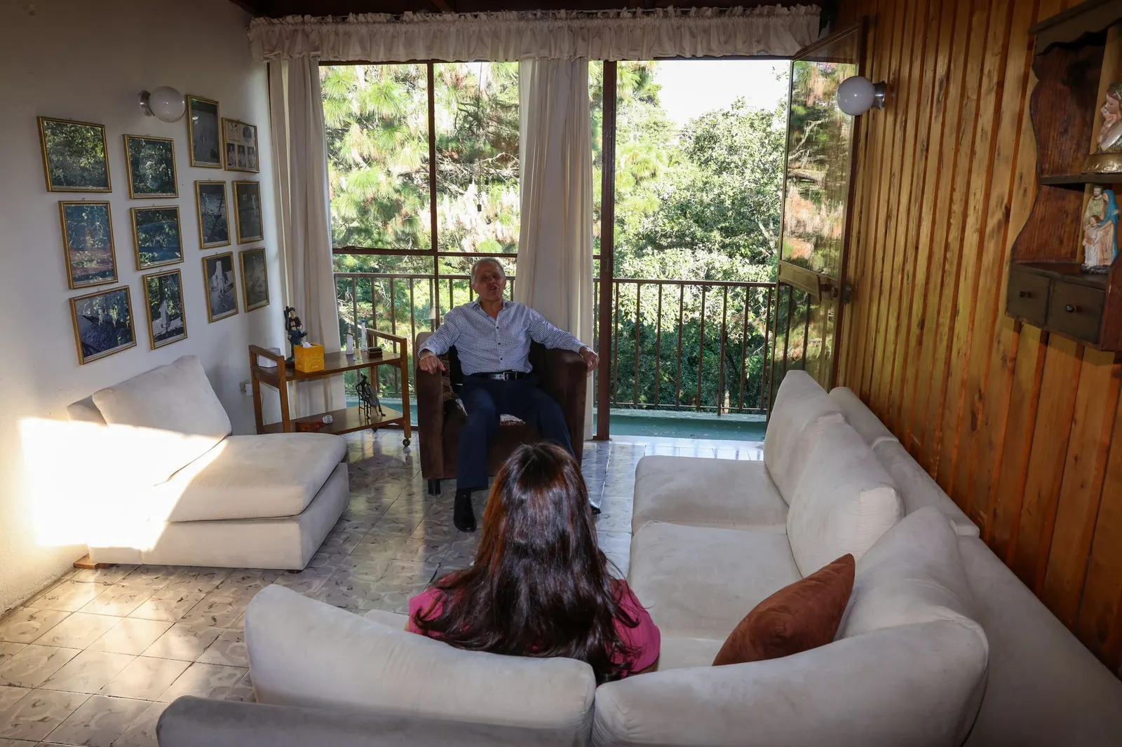 Lic. Fernando Estrada conversando con una paciente durante una sesión, ambos sentados frente a frente junto a un balcón con vista a los árboles